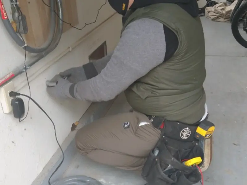 Electrician performing outlet wiring in a Manlius garage